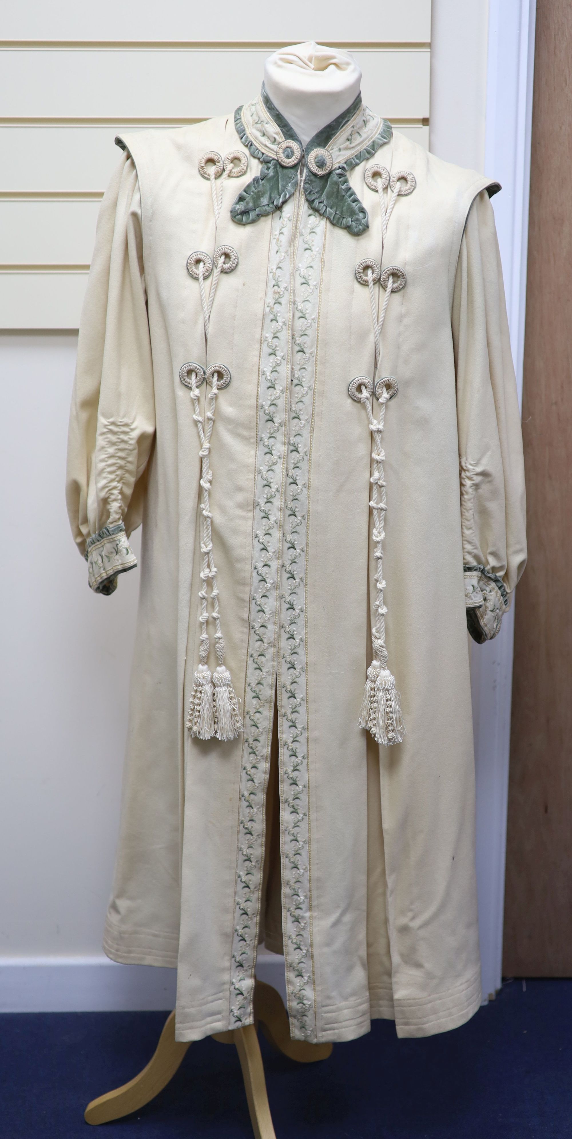 An Edwardian ladies fine cream wool coat with embroidered cuffs front edging and collar and ornate corded tasselling,